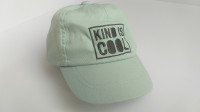 Otroška kapa s ščitom / šilt kapa z napisom "Kind Is Cool"
